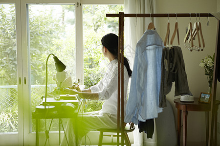 女人居家使用缝纫机休闲高清图片素材
