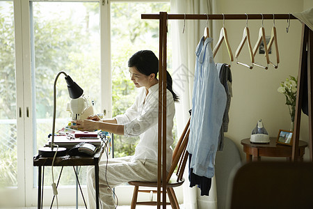 美女在家里缝衣服图片