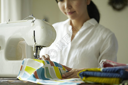 家庭妇女在缝纫机上缝衣服房子高清图片素材