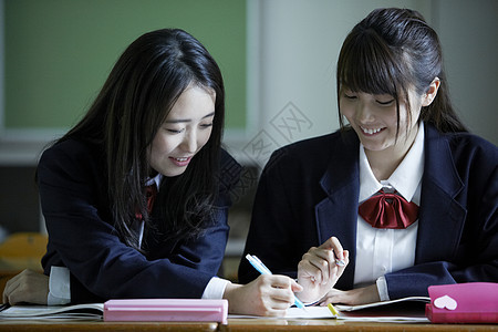 教室里的女学生互相请教学习图片