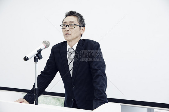 站在讲台上发表演讲的男人图片