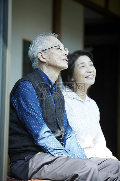 坐在房屋外欣赏风景的老夫妇形象图片