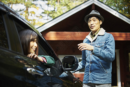 小屋外的男性与车里的女性交谈图片