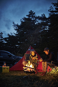 野外露营生篝火的情侣图片
