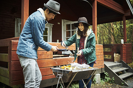 在木屋外烧烤食物的夫妇图片