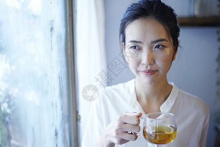 在窗口喝茶的美女图片