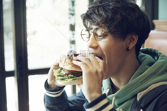 在餐厅吃午饭汉堡的男人图片