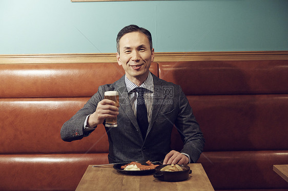 一个男人在餐厅喝啤酒图片