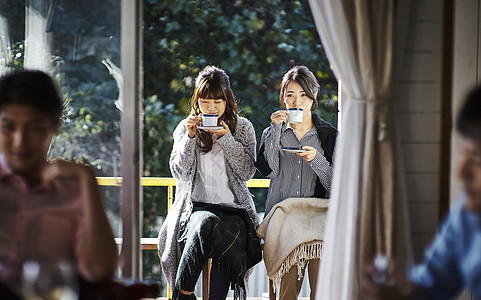 阳台喝咖啡的妇女图片