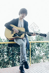 在阳台的弹吉他的大学生图片