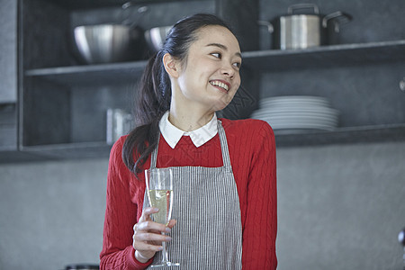 厨房里手拿酒杯的妇女图片