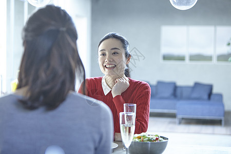 边吃午餐边交谈的年轻女子图片