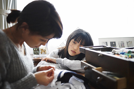 缝纫裁剪母亲缝合女孩的衣服背景