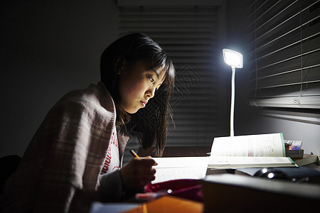 年轻的女孩在自己的房间里学习图片