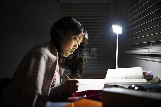 年轻的女孩在自己的房间里学习图片