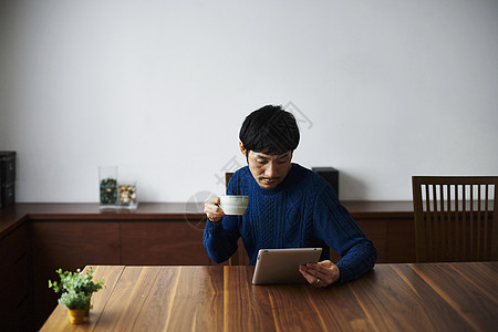 喝咖啡看平板电脑的男性图片