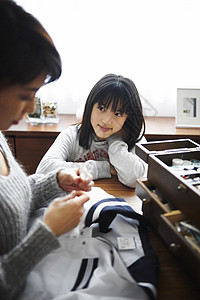 母亲帮女儿缝补衣服图片