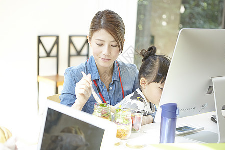 女性在办公室里照顾孩子吃饭图片