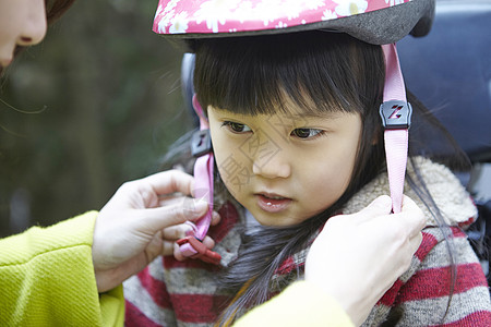 妈妈帮孩子系头盔图片