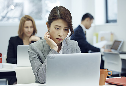 办公室里的职业女性托腮思考图片素材