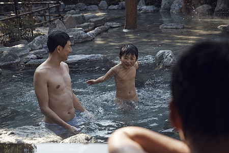 父亲和儿子在户外温泉里图片