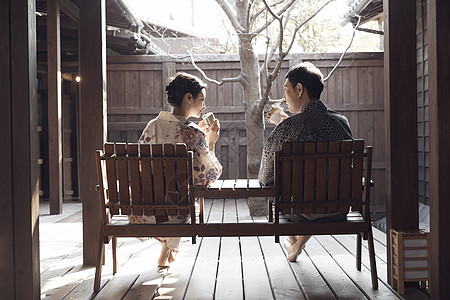 在温泉酒店的一对夫妇坐在木椅上喝茶休息图片素材