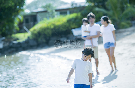 父母和孩子沿着海滩散步图片