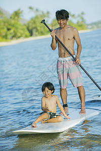 父子在玩海上桨板运动图片