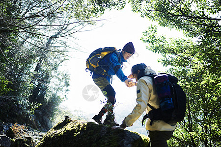 森林中徒步旅行的男人互相帮助图片