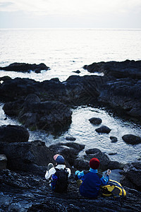 海边徒步旅行的背包客背影图片