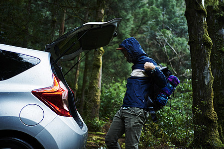 森林中男子将背包装入汽车图片