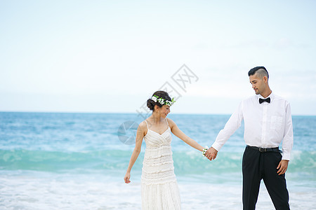 海滩边牵手的新婚夫妻图片