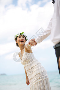 海滩边牵手的新婚夫妻图片