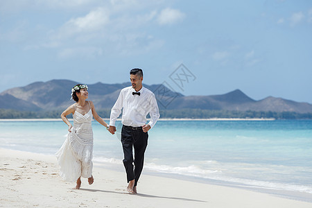 走在海滩上的新婚夫妇图片