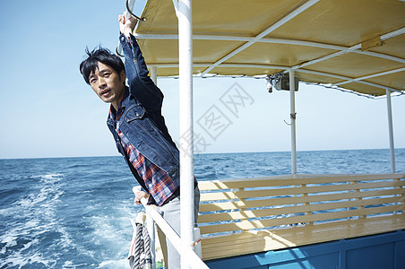 男子从船上欣赏海上美景图片