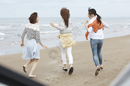 三个女孩一起在海边奔跑享受旅行图片