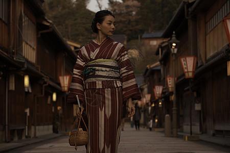 穿着和服的妇女走在光线昏暗的街头图片