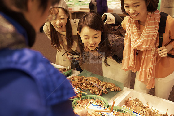三个休假旅行的女生在集市挑选美食图片