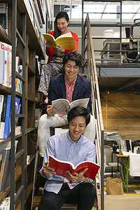 在楼梯上阅读书籍的职场人士图片