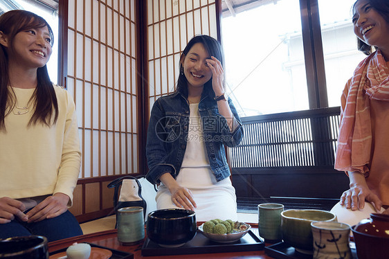 在金泽旅行的妇女店内品尝日式甜点图片