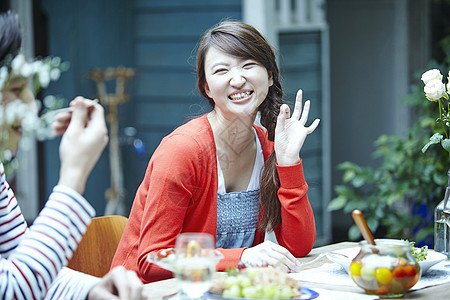 微笑挥手的女子和老公一起露天用餐图片