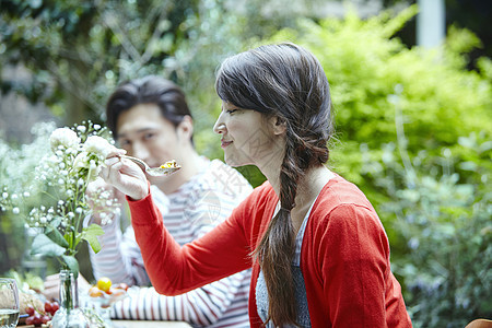 年轻情侣在户外欣赏美丽的花图片