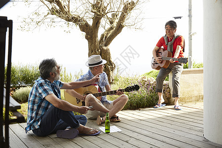 三个快乐的老人在露台举行音乐派对图片