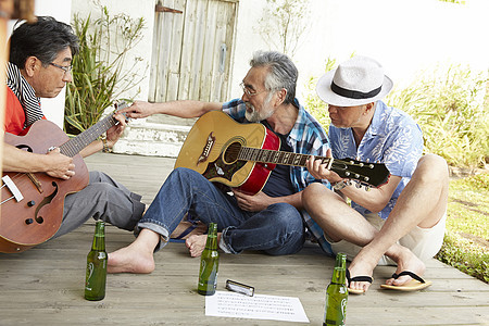 三个快乐的老人在露台举行音乐派对图片