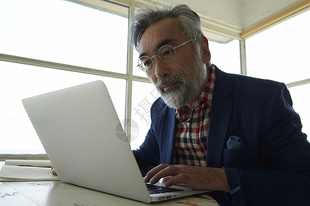 年长的男人在用平板电脑工作图片