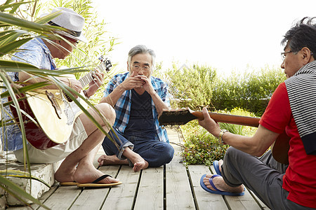 三个快乐的老人在露台举行音乐派对
图片
