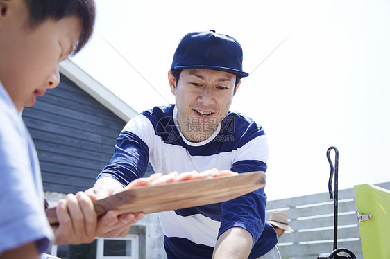 烧烤派对上男子接过小孩的食材图片