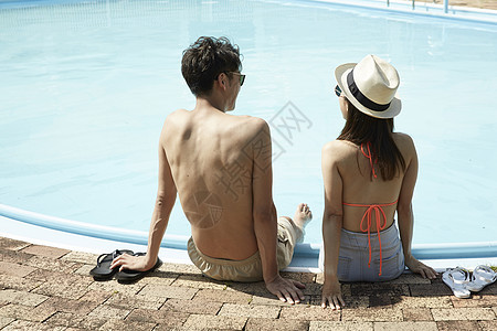 年轻情侣在游泳池边背影图片