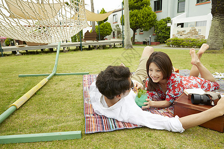 年轻情侣度假约会在野餐垫上休息图片