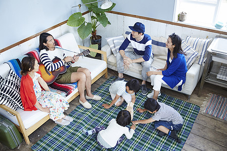 客厅里家庭聚会聊天的大人和玩耍的孩子图片